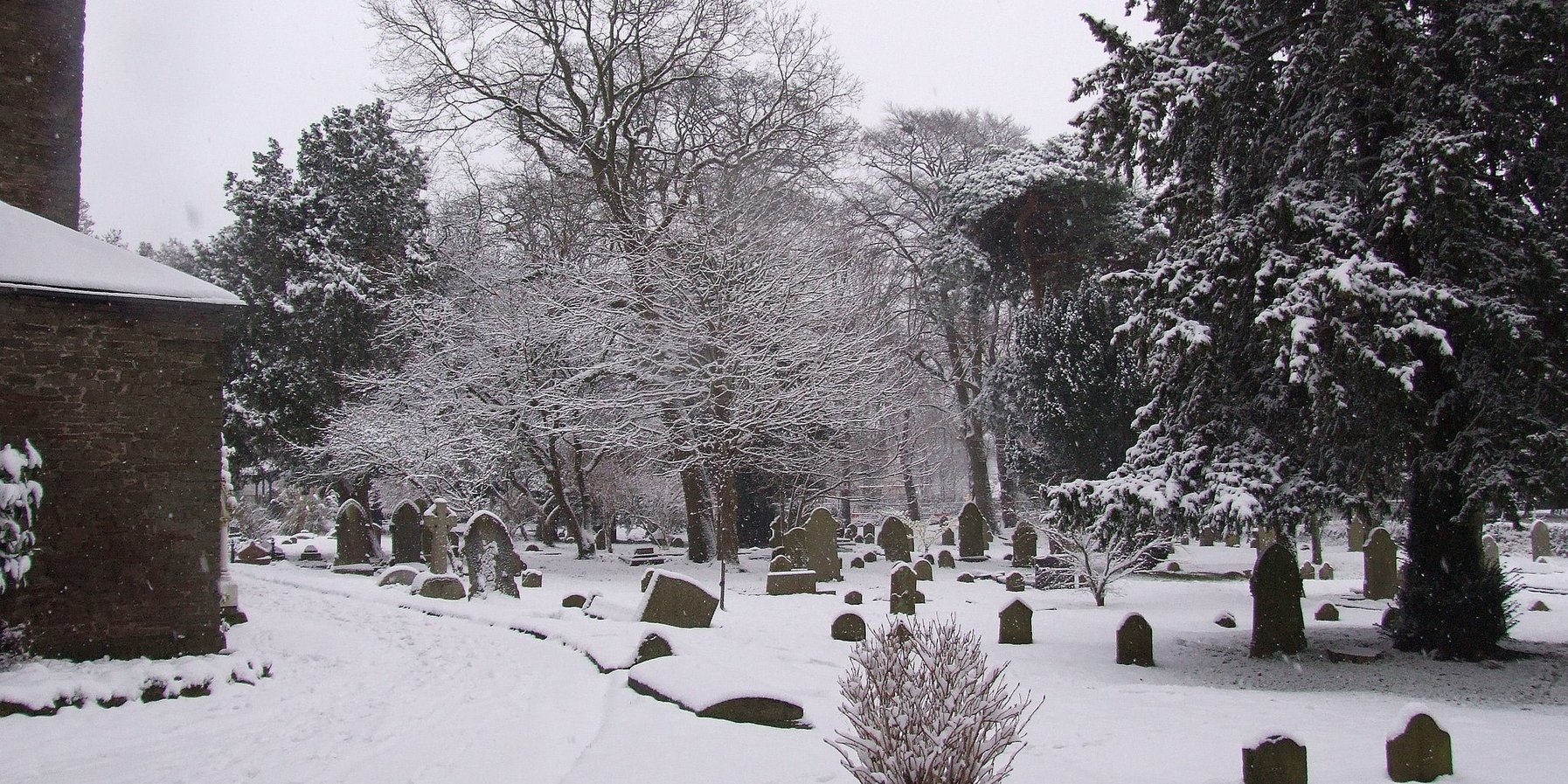 schneebedeckter alter Friedhof